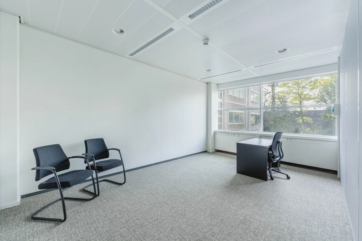 Licht en minimalistisch kantoor aan de Laarderhoogtweg met bureau, bureaustoel en twee bezoekersstoelen.