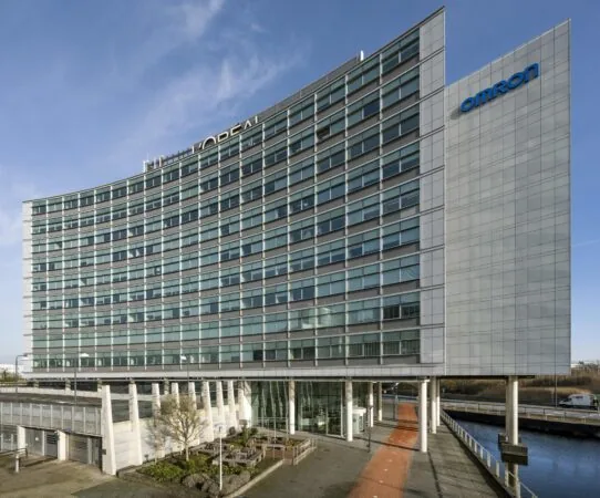 Modern kantoorgebouw Scorpius in Hoofddorp met gevels van glas en logo’s van L'Oréal en Omron.