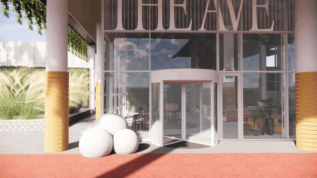 De ingang van gebouw The Avenue met een glazen draaideur, grote ronde decoratieve objecten en gele zuilen.