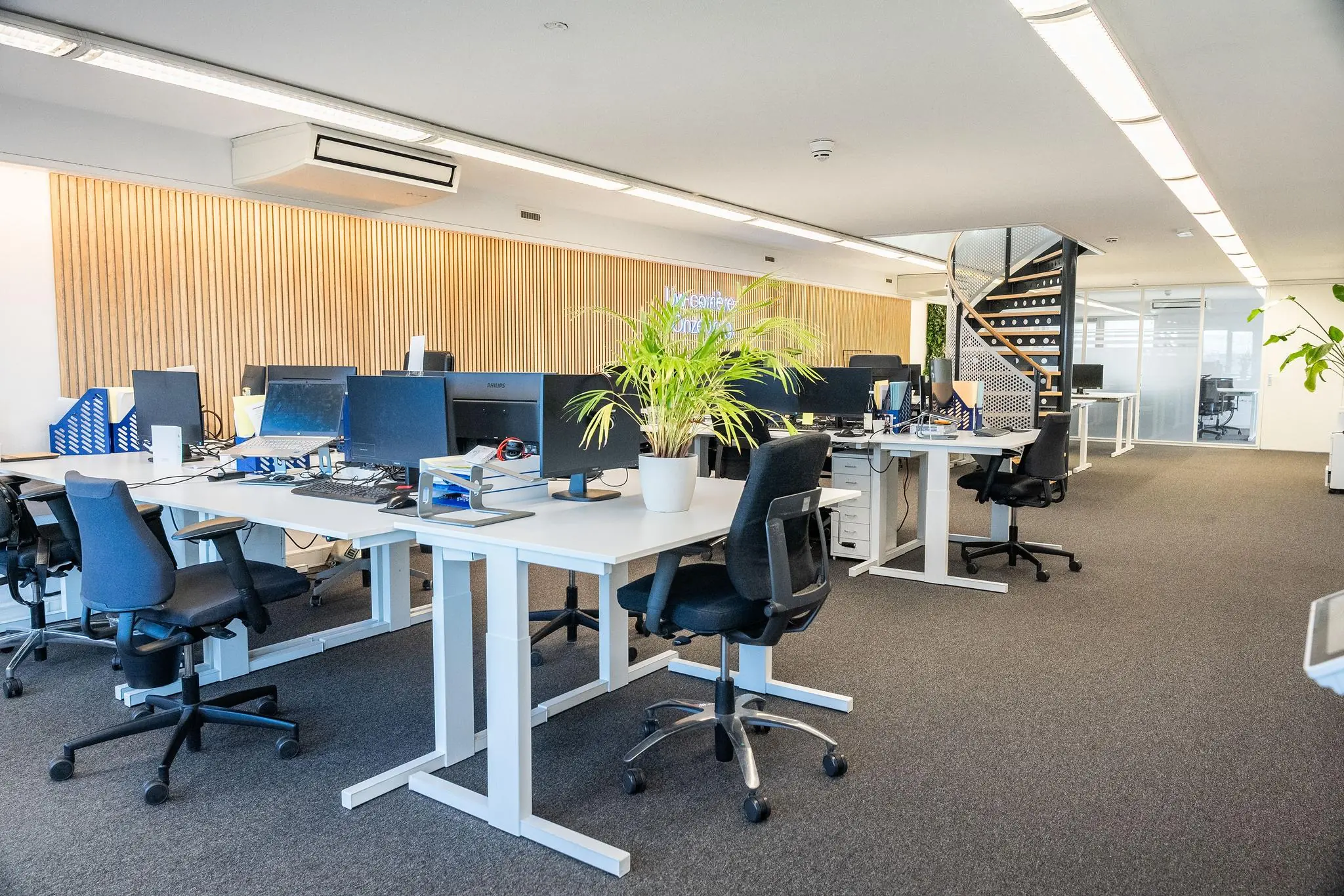 Moderne open kantoorruimte aan de Prins Hendrikkade met bureaus, computerschermen en planten.
