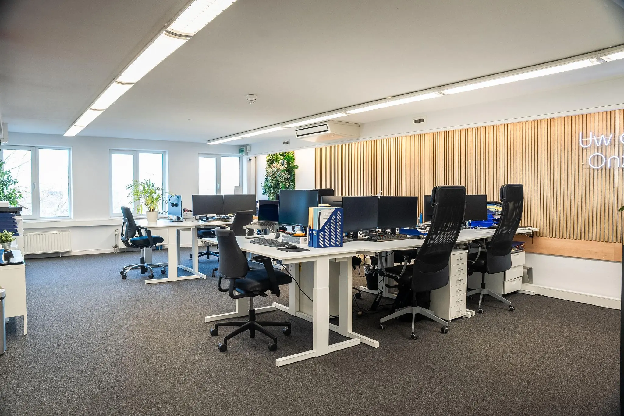 Modern kantoorinterieur aan de Prins Hendrikkade met meerdere bureaus, computers en ergonomische stoelen.