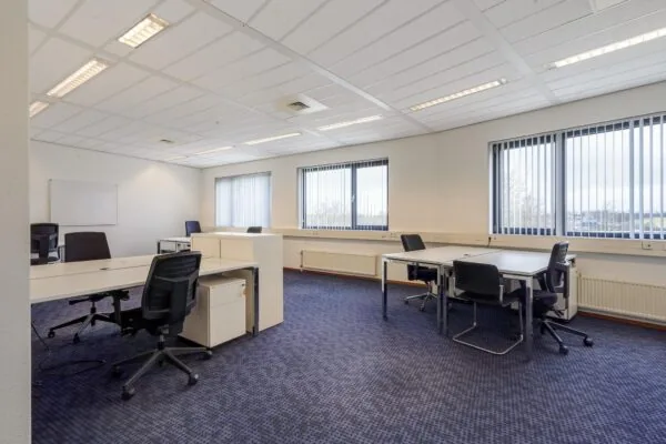 Licht en ruim kantoor aan de Laan van s-Gravenmade met meerdere werkplekken en grote ramen met verticale lamellen.