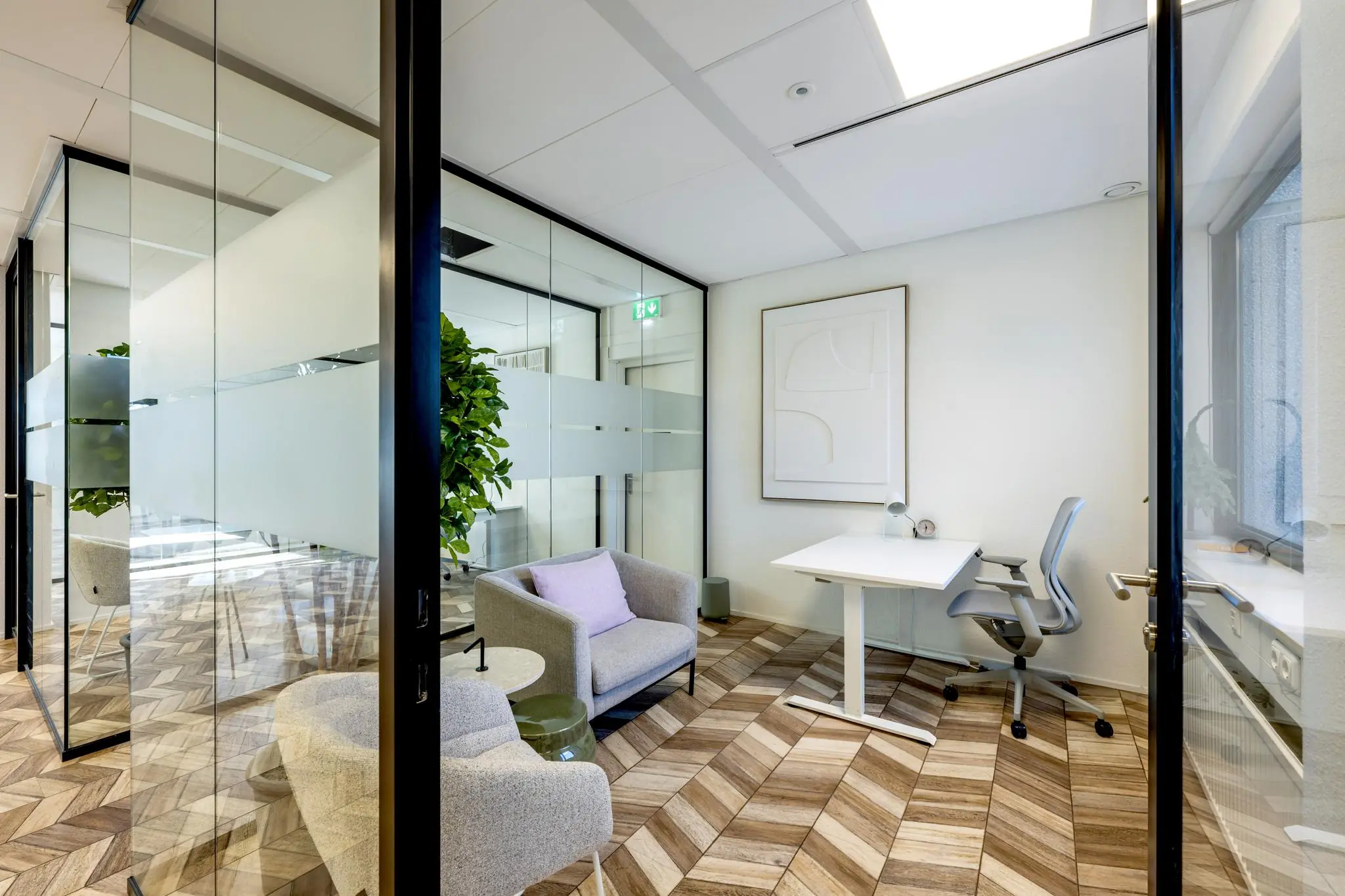 Moderne, licht ingerichte kantoorruimte aan de Overschiestraat met glazen wanden, zithoek en werkplek.