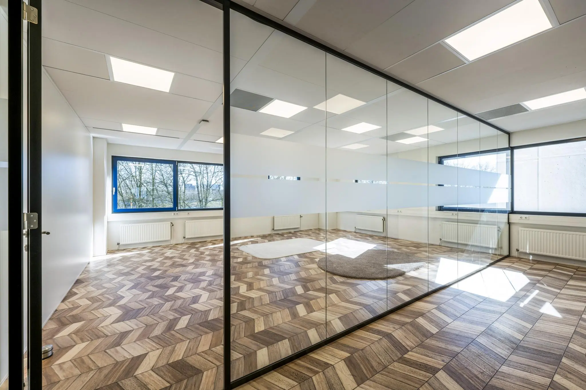 Licht en modern kantoor aan de Overschiestraat met glazen scheidingswand en visgraatvloer.