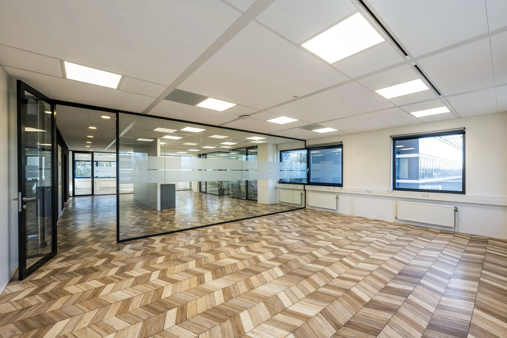 Modern en licht kantoor aan de Overschiestraat met glazen wanden en een visgraatvloer.