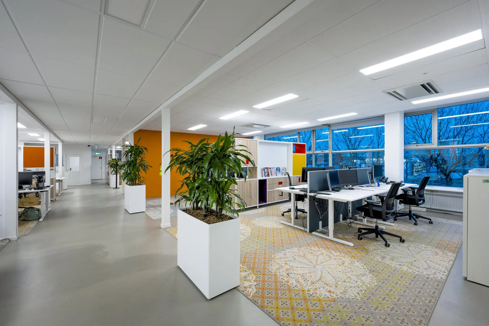 Modern kantoorinterieur aan de Van der Madeweg met werkplekken, grote ramen en groene planten.