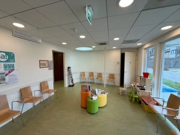 Wachtruimte met stoelen, tijdschriften, kinderspeelgoed en een speeltafel in een gezondheidscentrum aan de Fonteynenburghlaan.