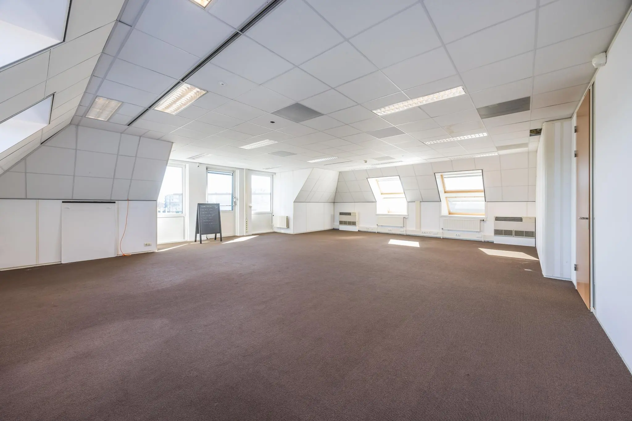 Lichte, ruime zolderverdieping aan de Dorpsstraat met schuine wanden, systeemplafond en meerdere dakramen.