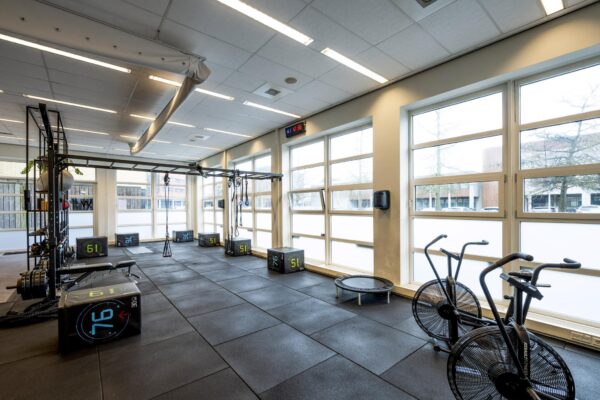 Moderne fitnessruimte aan de H.J.E. Wenckebachweg met fitnessapparatuur, plyoboxen en grote raampartijen.