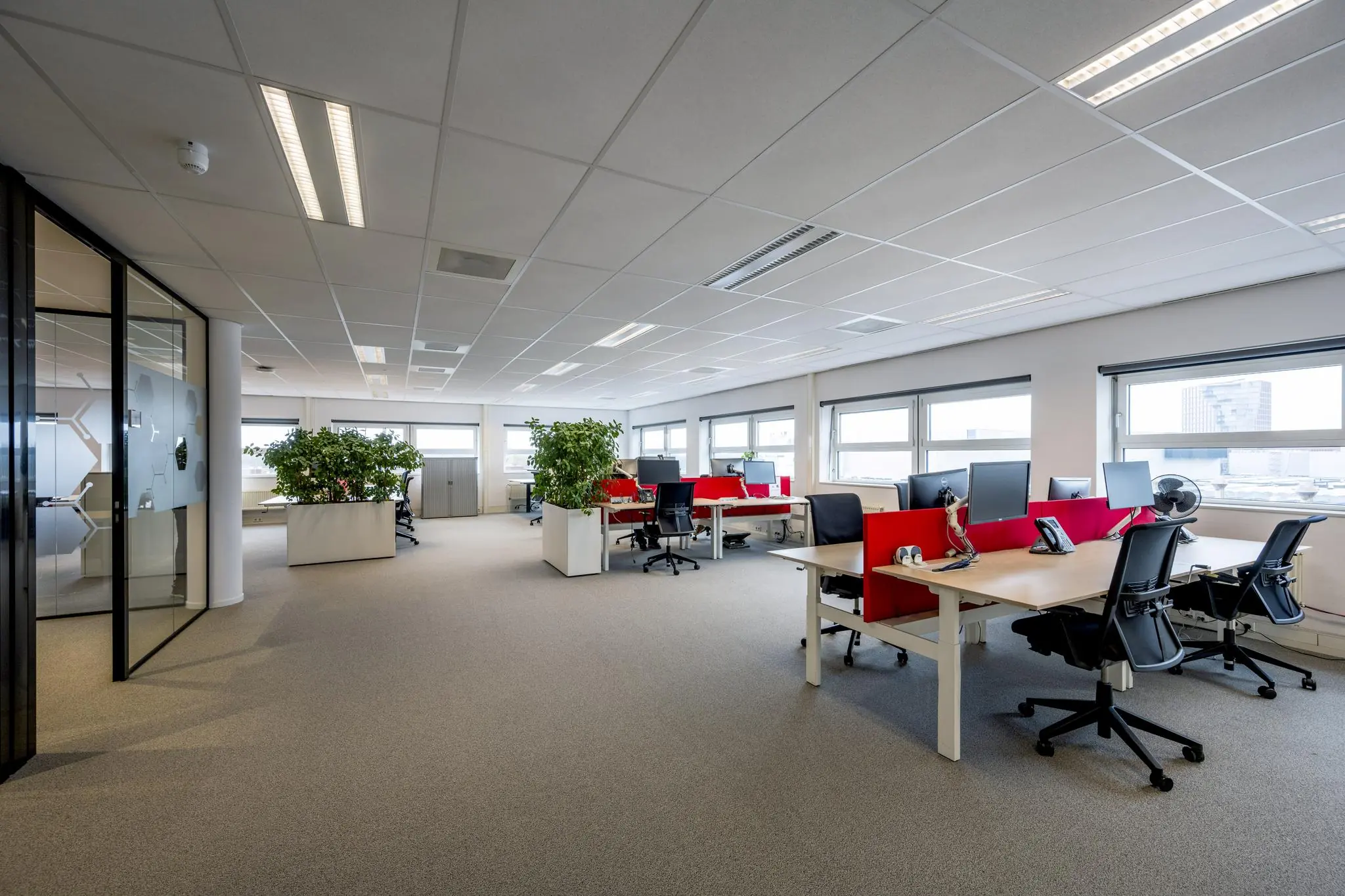 Modern kantoorinterieur aan de H.J.E. Wenckebachweg met open werkplekken, bureaustoelen, computers en planten.