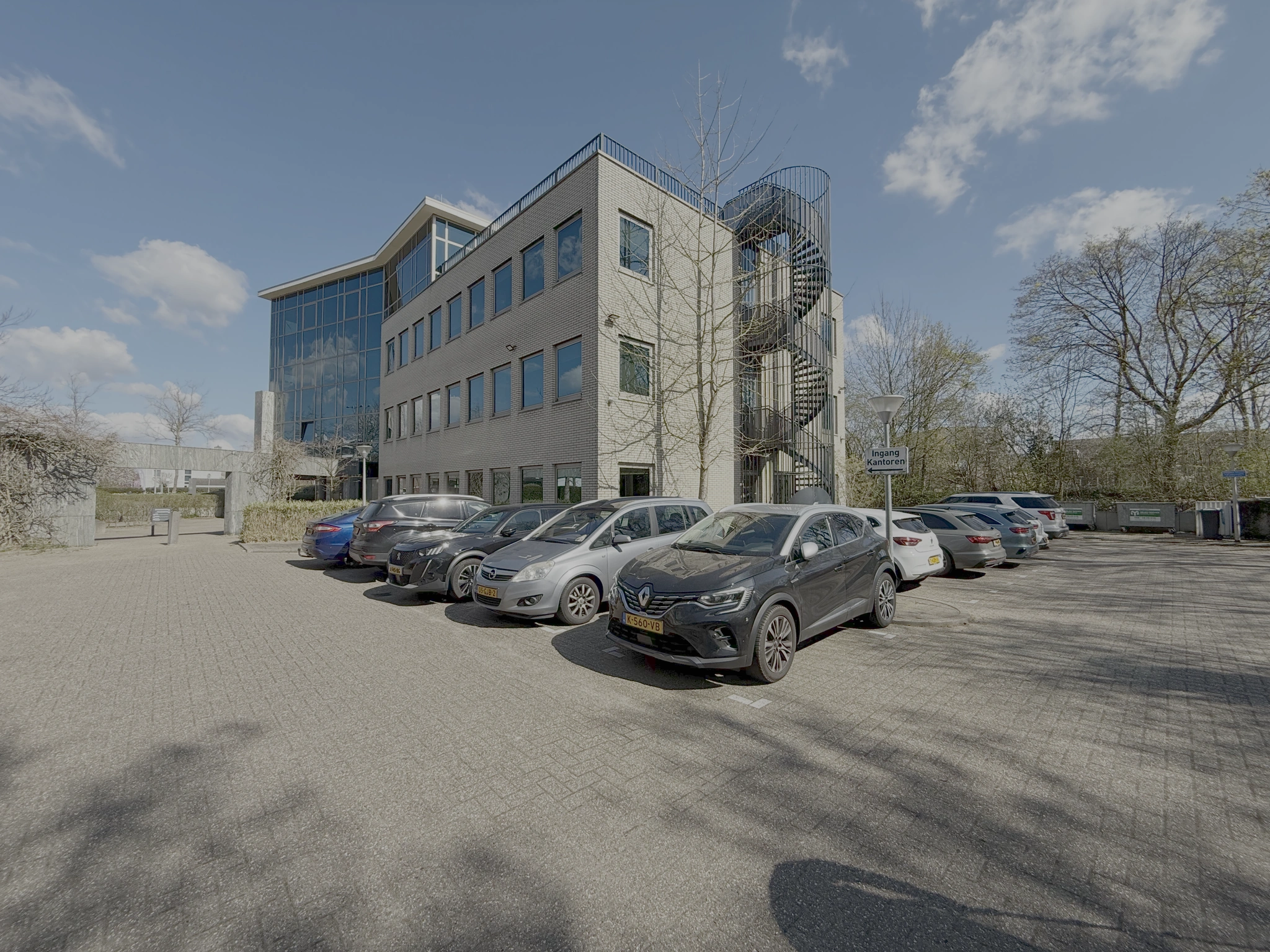 Kantoorgebouw aan de Lunettenbaan met parkeerplaatsen op de voorgrond.