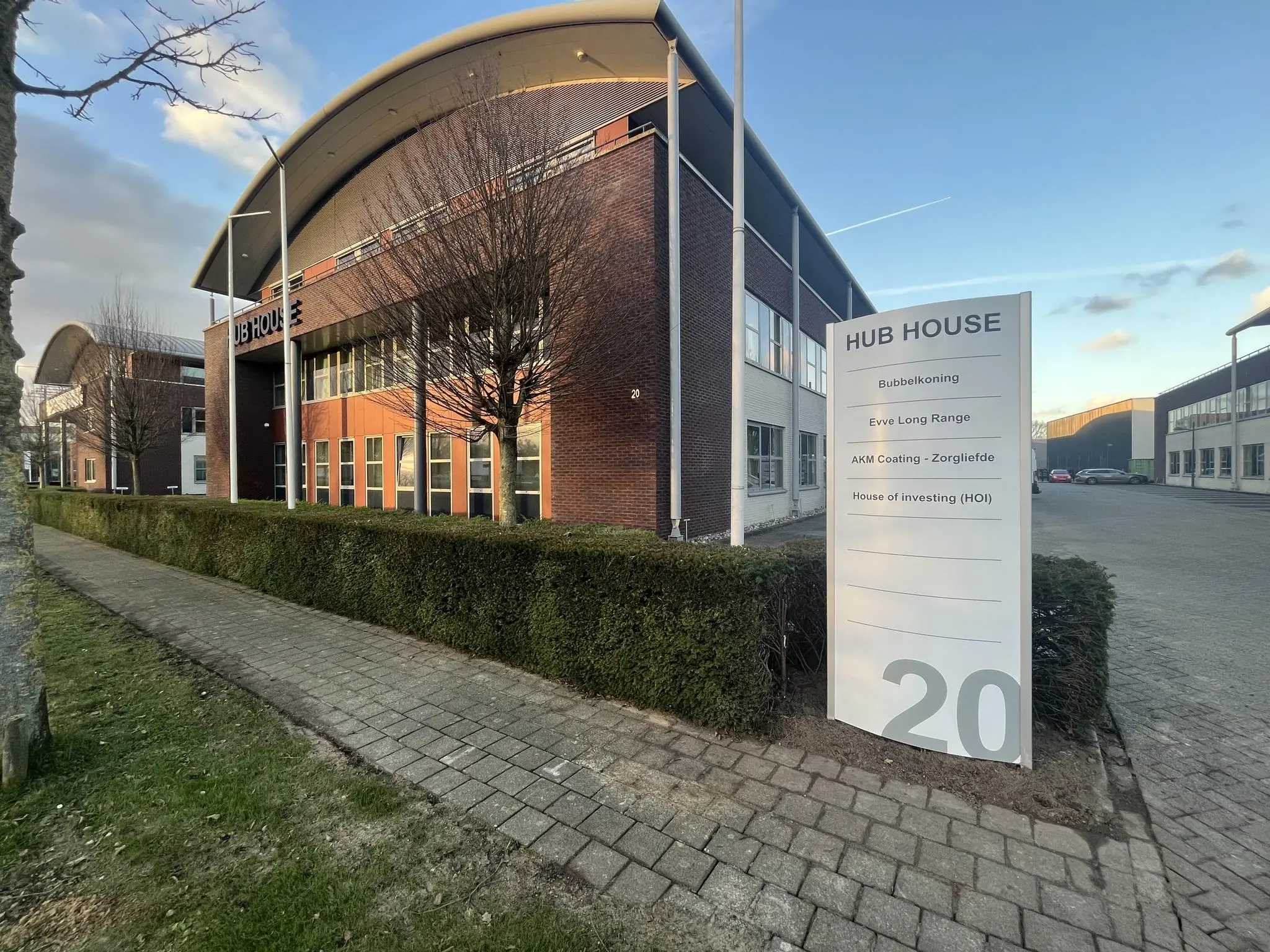 Bedrijfsverzamelgebouw HUB HOUSE met een bord waarop de namen van meerdere bedrijven en huisnummer 20 staan vermeld.