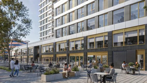 Terras met mensen voor een modern kantoorgebouw aan de H.J.E. Wenckebachweg in Amsterdam.