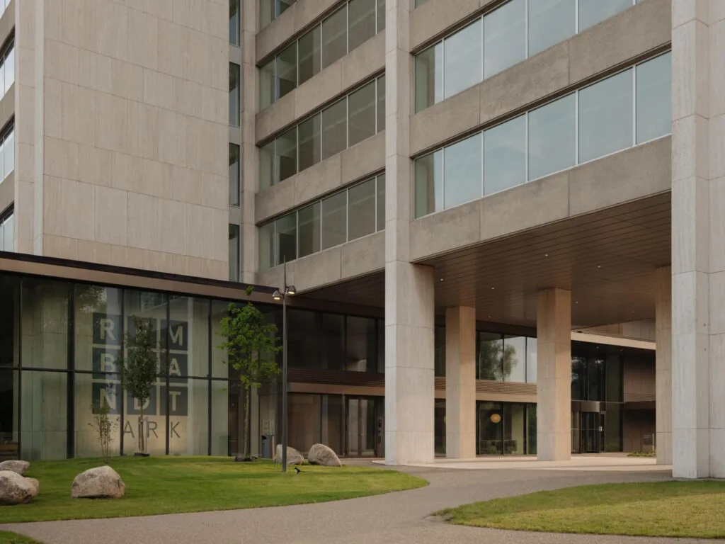 Ingang van een modern kantoorgebouw aan de Nachtwachtlaan met de naam Rembrandt Park zichtbaar op de gevel.