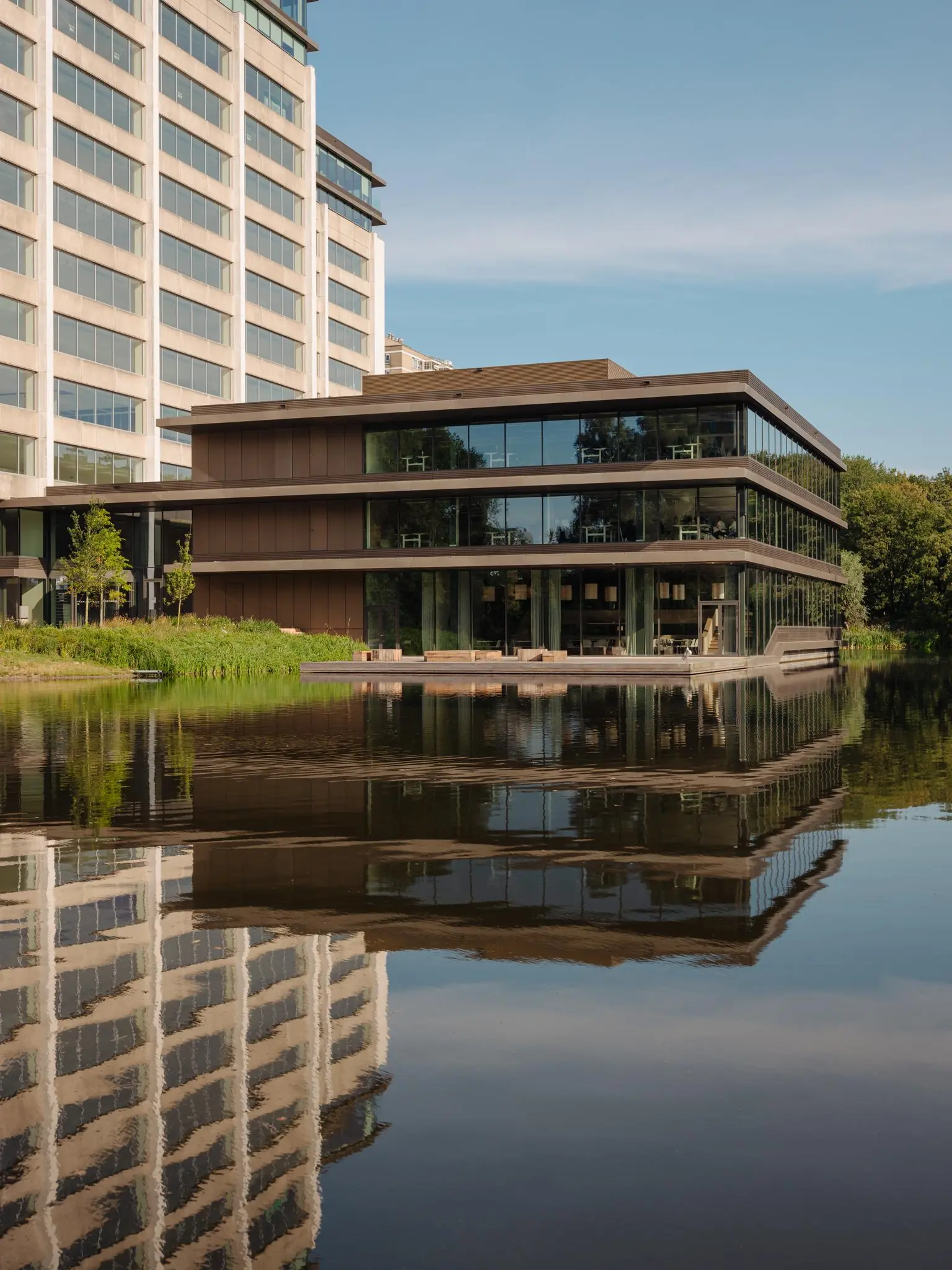 Modern kantoorgebouw aan de Nachtwachtlaan in Amsterdam met reflectie in het water.