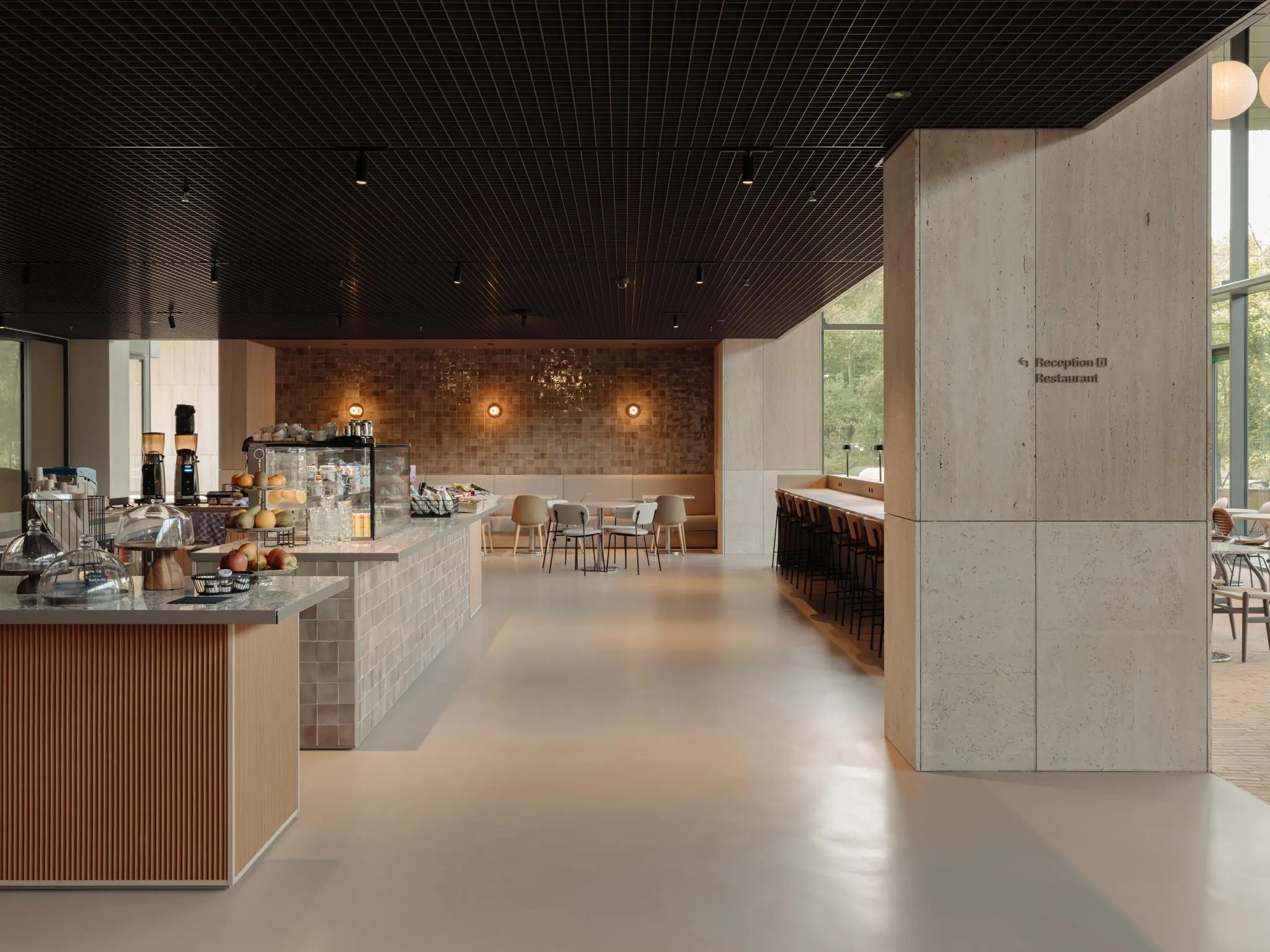 Modern ingerichte koffiebar en eetruimte aan de Nachtwachtlaan met warme verlichting en zithoeken.