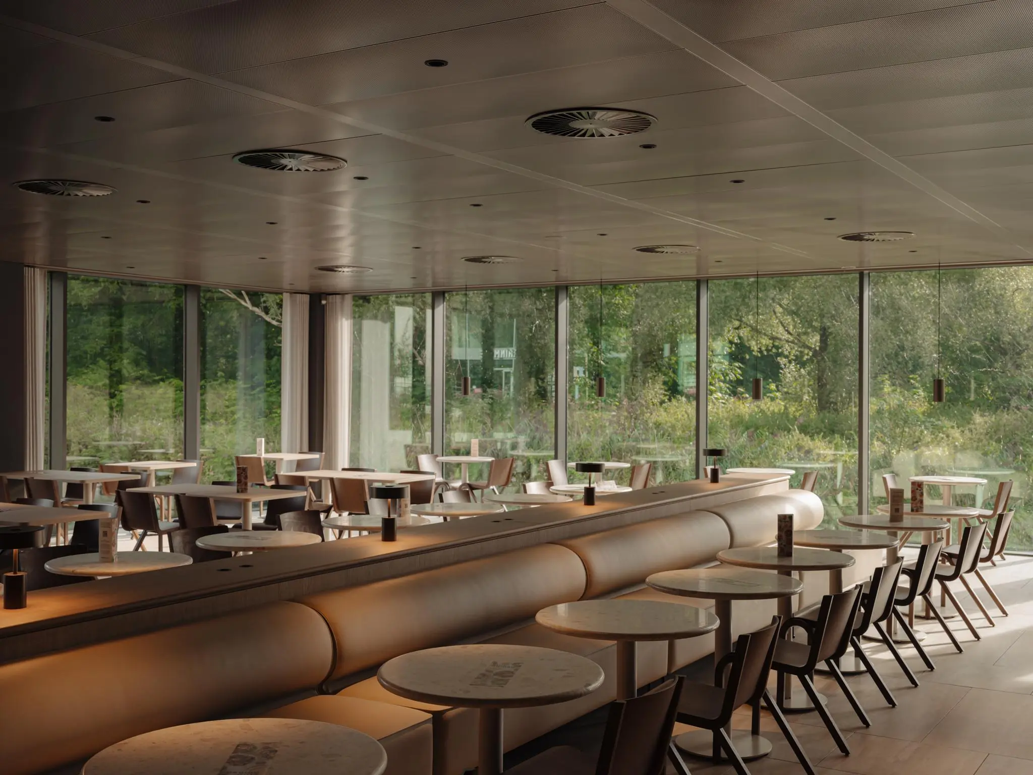 Modern ingerichte, lege horecaruimte aan de Nachtwachtlaan met grote ramen en uitzicht op groen.