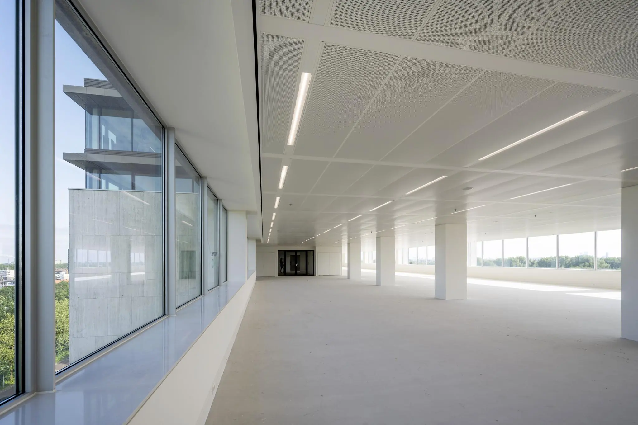 Lichte, lege kantoorruimte aan de Nachtwachtlaan met grote ramen en uitzicht op de omgeving.