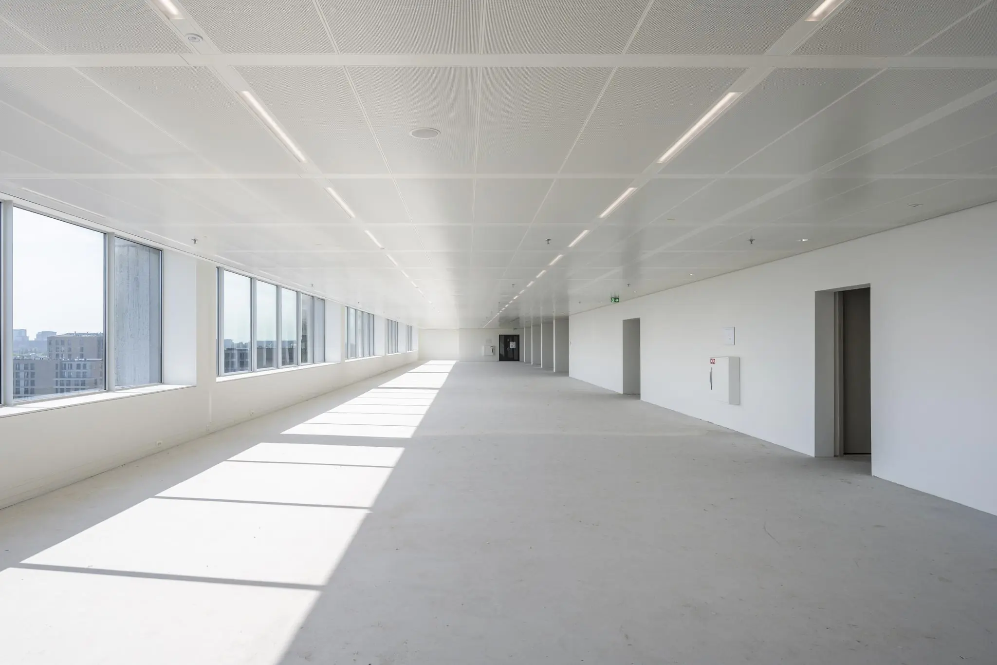 Licht en leeg kantoorpand aan de Nachtwachtlaan met grote ramen en uitzicht over de stad.