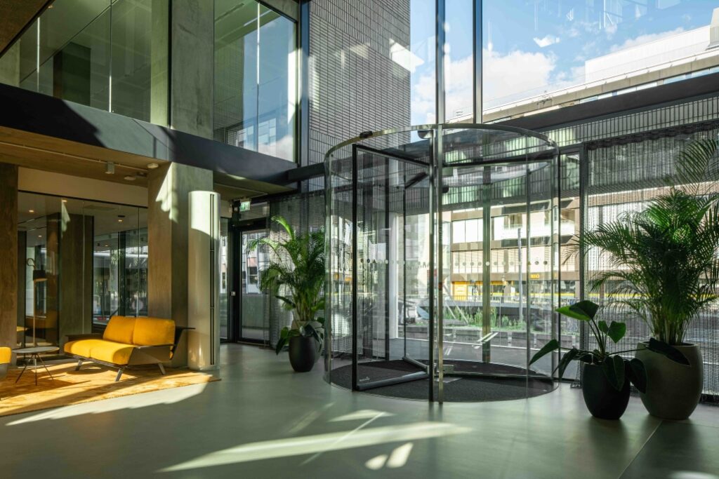 Moderne entreehal van een kantoorgebouw aan de Catharijnesingel met glazen draaideur, veel lichtinval en stijlvolle inrichting.