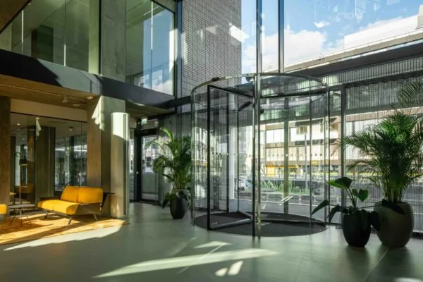 Moderne entreehal van een kantoorgebouw aan de Catharijnesingel met glazen draaideur, veel lichtinval en stijlvolle inrichting.