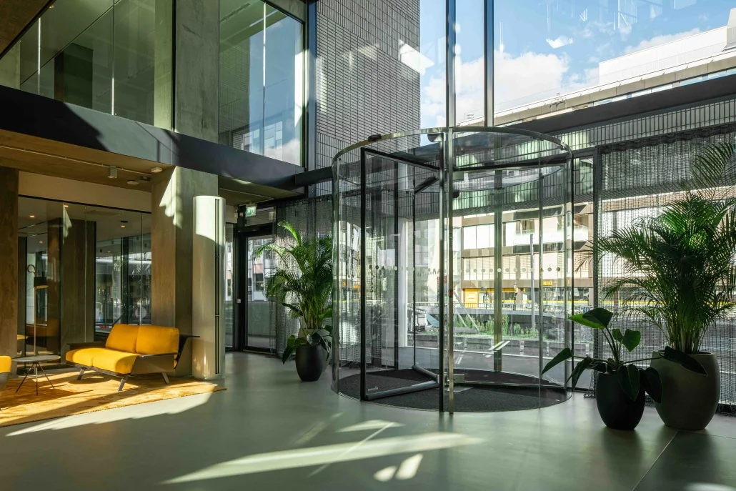 Moderne entreehal van een kantoorgebouw aan de Catharijnesingel met glazen draaideur, veel lichtinval en stijlvolle inrichting.