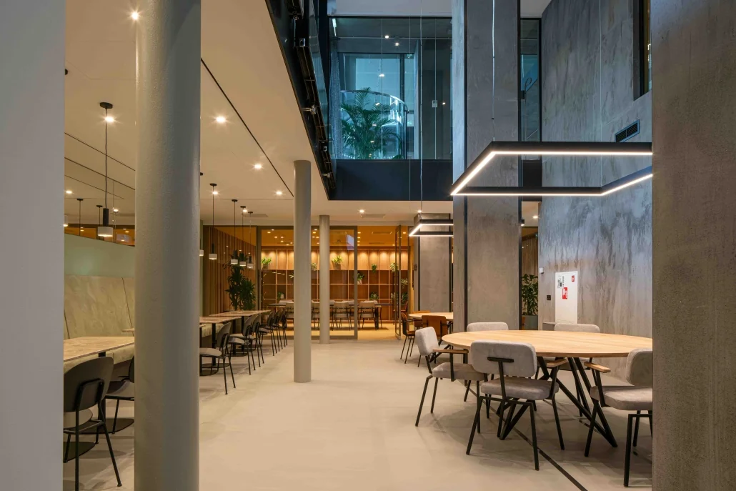 Moderne en ruimtelijke kantoorruimte aan de Catharijnesingel met houten tafels, designstoelen en hangende verlichting.
