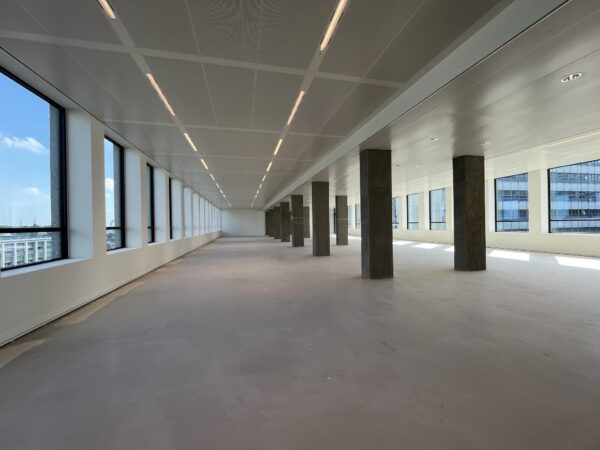 Lichte, leegstaande kantoorruimte aan de Catharijnesingel met grote ramen en betonnen zuilen.