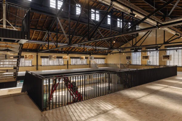 Interieur van een industrieel gerenoveerd gebouw aan de Leidseweg met zicht op de houten dakconstructie, zwarte stalen balken en moderne balustrades.