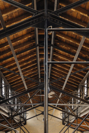 Interieur van een industrieel gebouw aan de Leidseweg met een houten dakconstructie en stalen spanten.