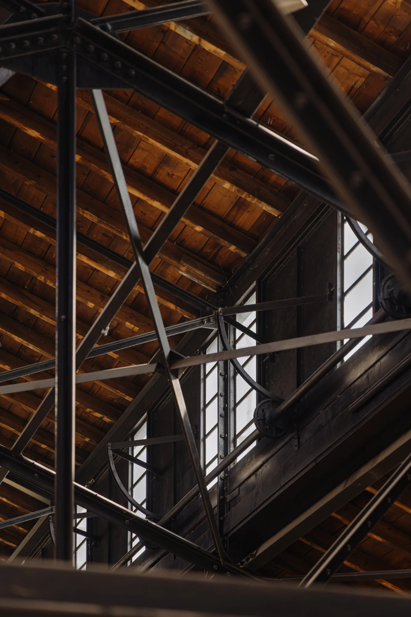 Detail van een houten dakconstructie met stalen spanten en industriële ramen in een gebouw aan de Leidseweg.