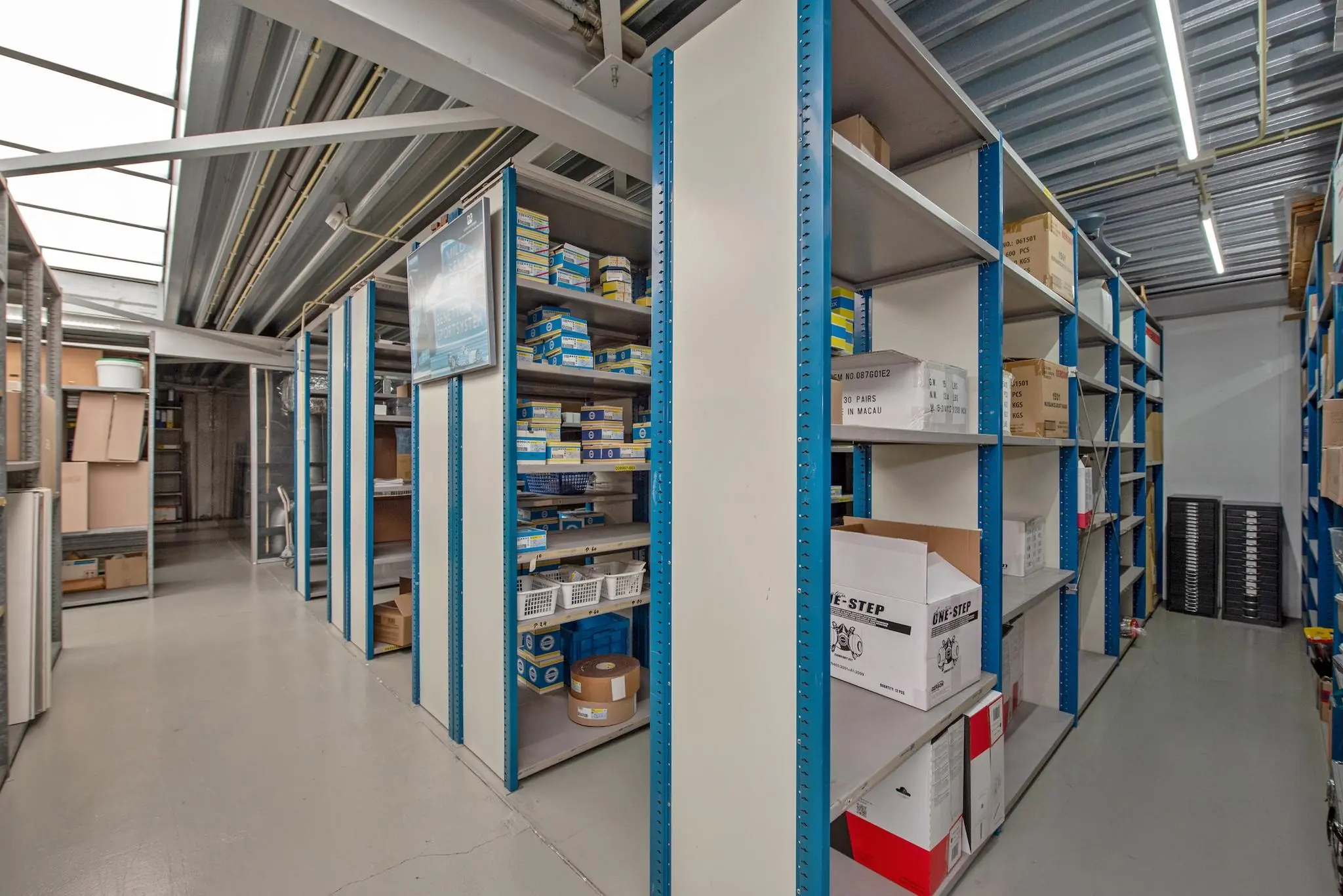 Opslagruimte met metalen stellingen gevuld met dozen en auto-onderdelen aan de Lagosweg.