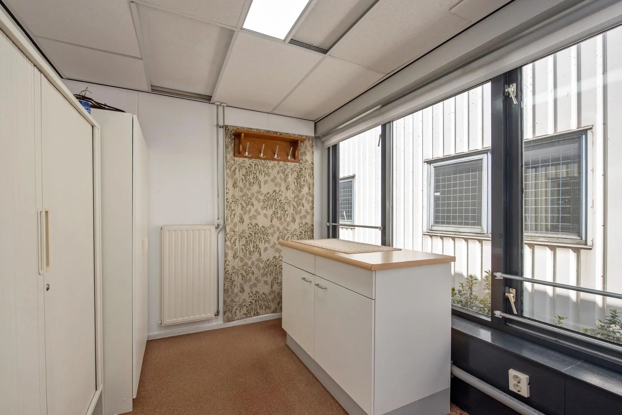 Kleine, lichte kamer met een kast, aanrecht en grote ramen aan de Lagosweg.