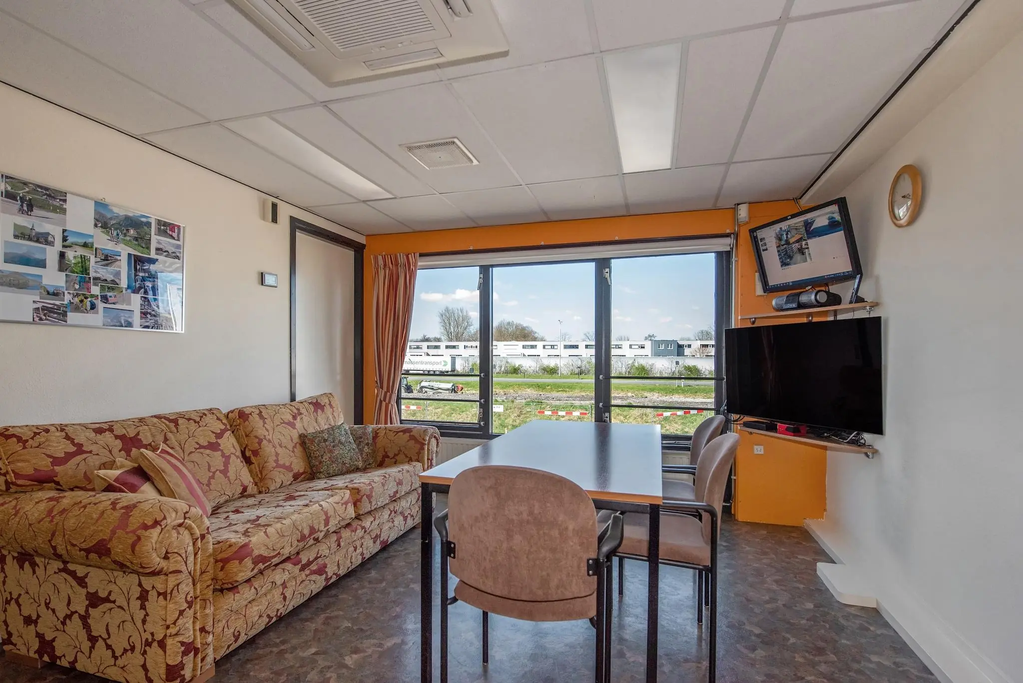 Woonkamer met zithoek, eettafel en groot raam met uitzicht op de Lagosweg.