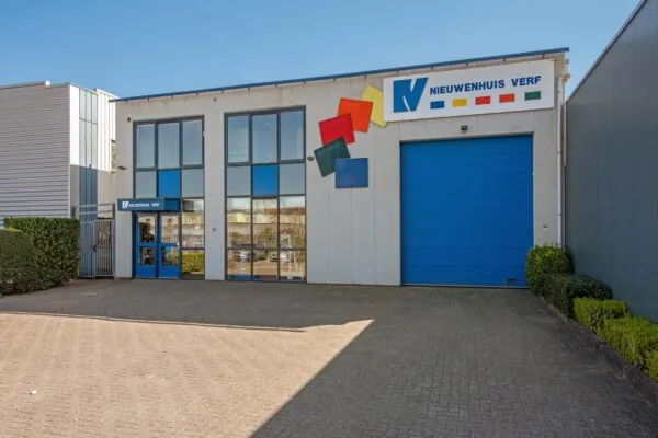 Vooraanzicht van het bedrijfsgebouw van Nieuwenhuis Verf aan de Lagosweg met grote blauwe garagedeur en kleurrijk logo.