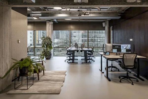Modern kantoorinterieur in Hofplein met werkplekken, grote ramen en industriële details.