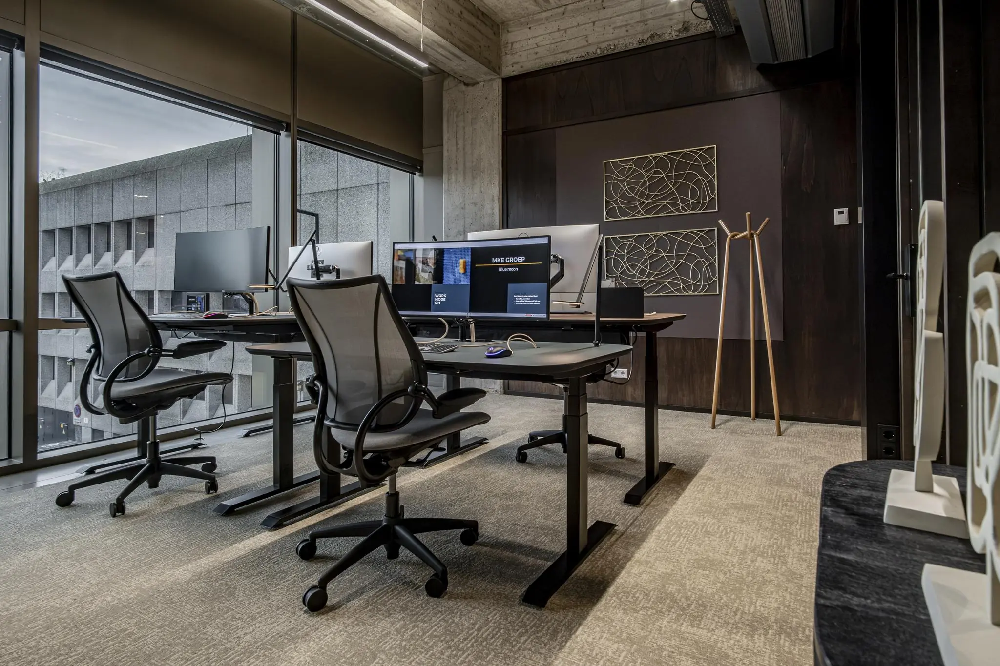 Modern kantoorinterieur in Hofplein met ergonomische bureaustoelen, dubbele beeldschermen en kunst aan de muur.