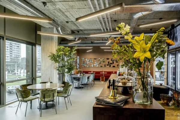 Modern ingericht horecagedeelte in Hofplein met bloemen op de voorgrond en uitzicht op de stad.