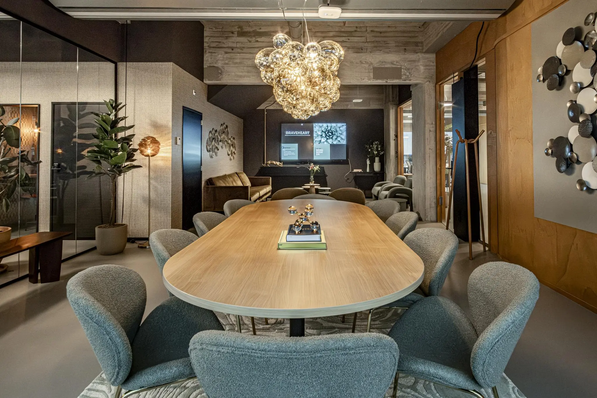 Stijlvol ingerichte vergaderruimte aan het Hofplein met een lange houten tafel, moderne stoelen en een opvallende glazen hanglamp.