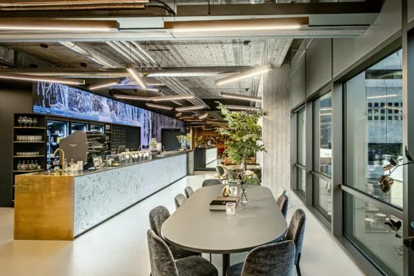 Moderne koffiebar met strakke inrichting en vergadertafel in een kantoorruimte aan het Hofplein.