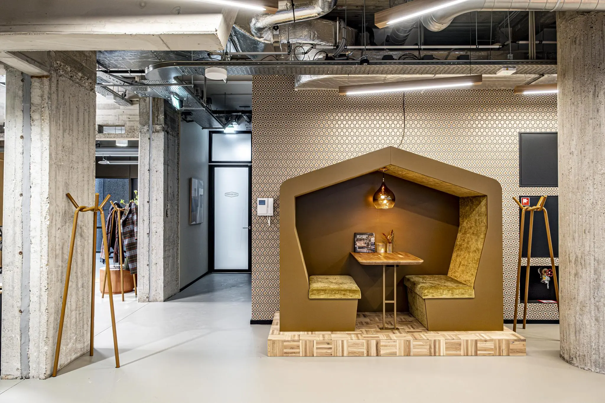 Stijlvolle werk- of overlegruimte in nisvorm met fluwelen banken, houten tafel en warme verlichting in een modern interieur aan het Hofplein.