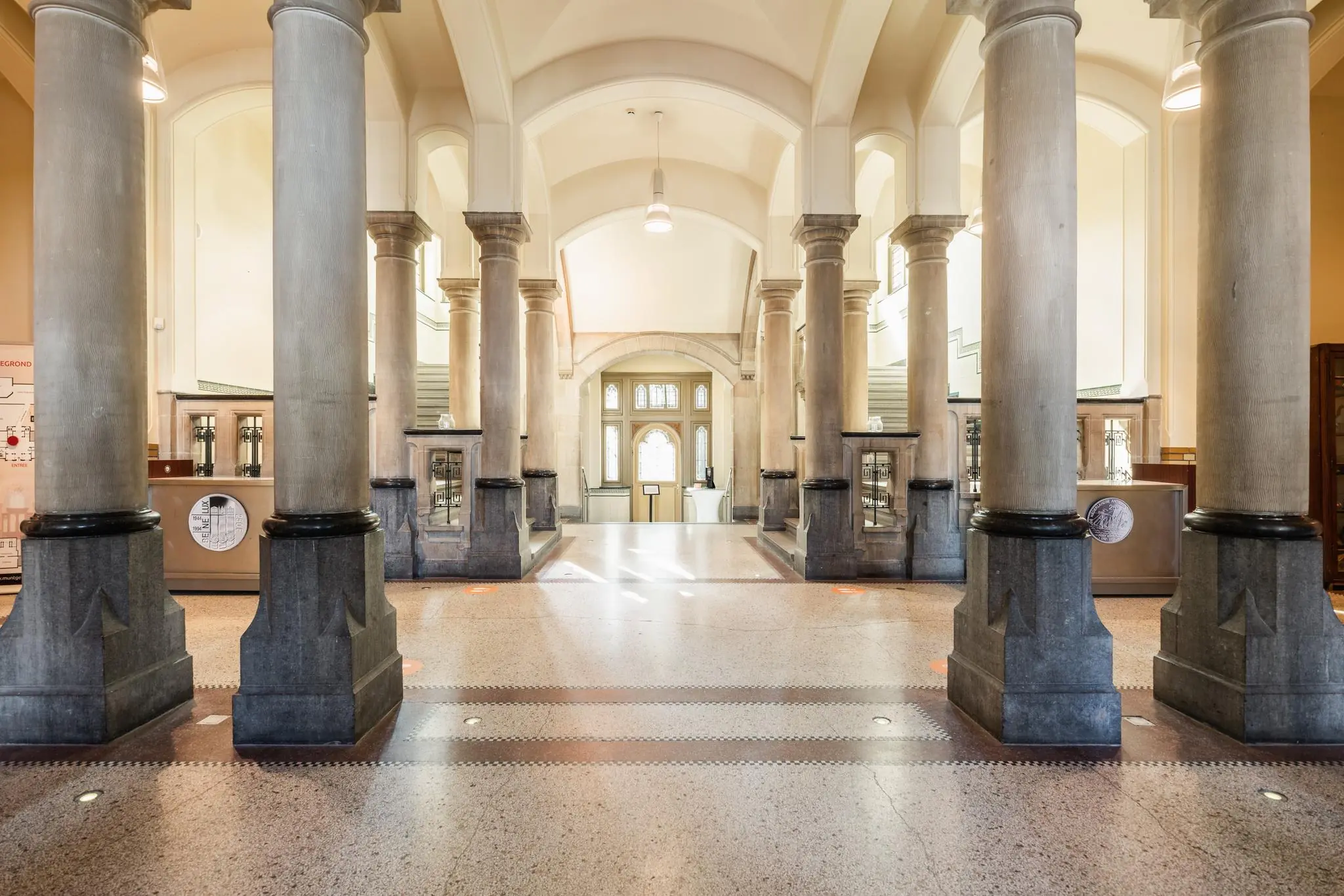 Monumentale entreehal van een klassiek gebouw aan de Leidseweg met hoge zuilen, natuurstenen vloer en symmetrische architectuur.
