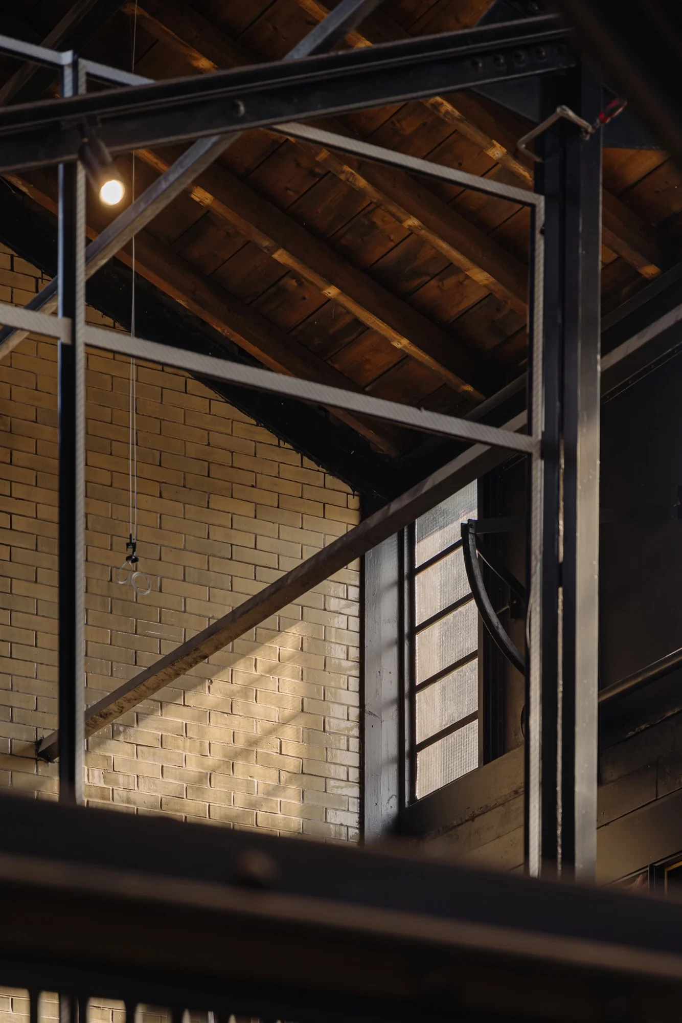Industriële binnenruimte aan de Leidseweg met zicht op een bakstenen muur, metalen constructie en houten dak.