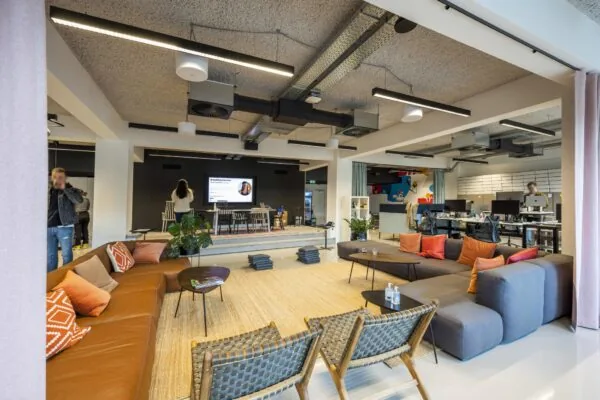 Moderne kantoorruimte aan de Singel met een loungehoek, podium en werkplekken in open indeling.