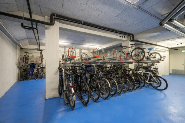 Fietsenstalling met dubbele rekken in een moderne, blauwe kelderruimte aan de Singel.