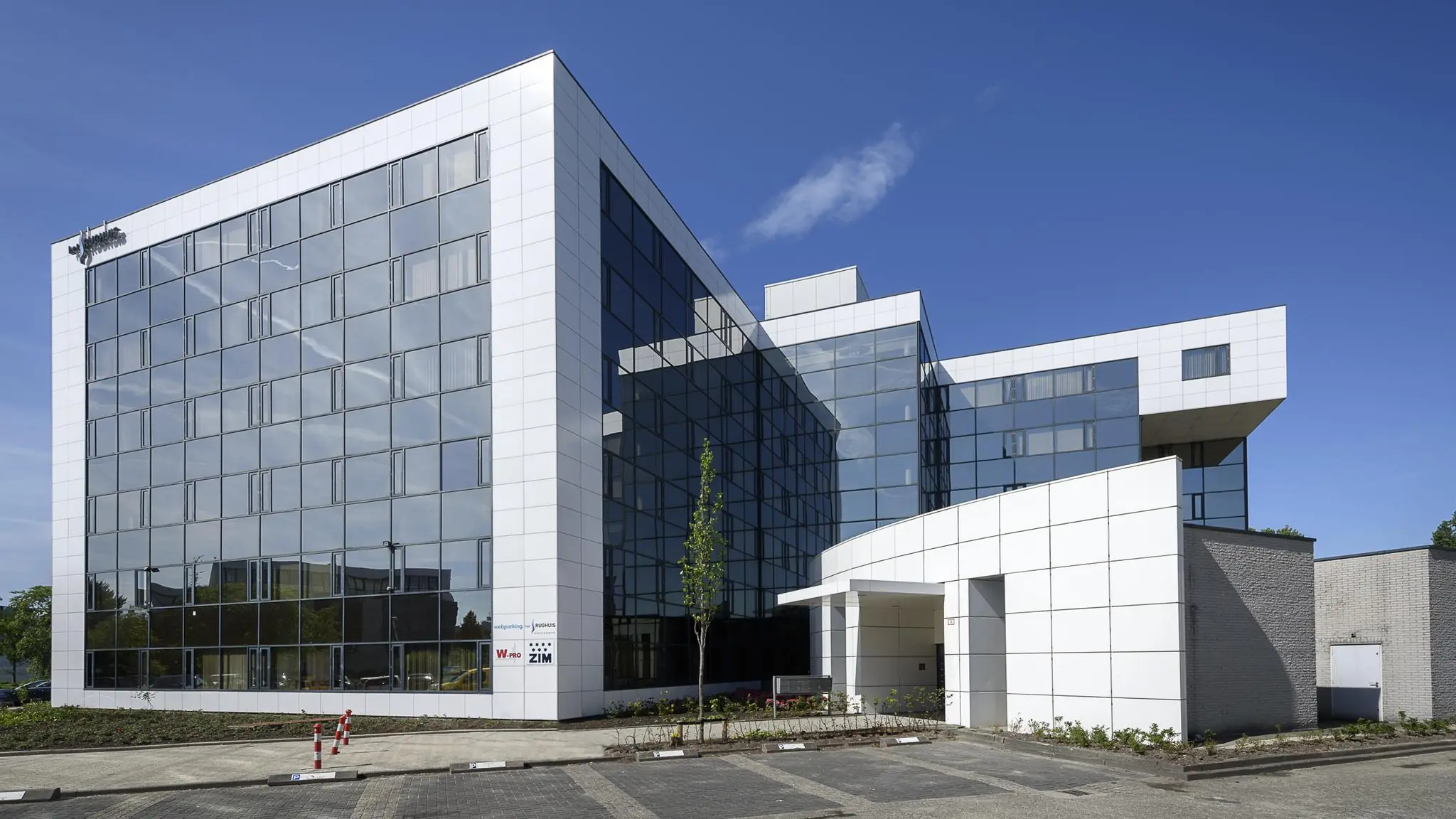 Modern kantoorgebouw aan de Cypresbaan met glazen gevel en witte panelen.