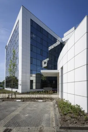 Modern kantoorgebouw aan de Cypresbaan met witte gevelpanelen en spiegelende ramen.