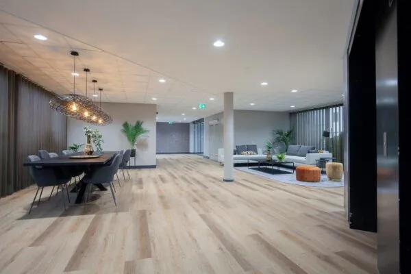 Moderne, ruim opgezette lounge- en vergaderruimte aan de Cypresbaan met strakke inrichting, houten vloer en stijlvolle verlichting.