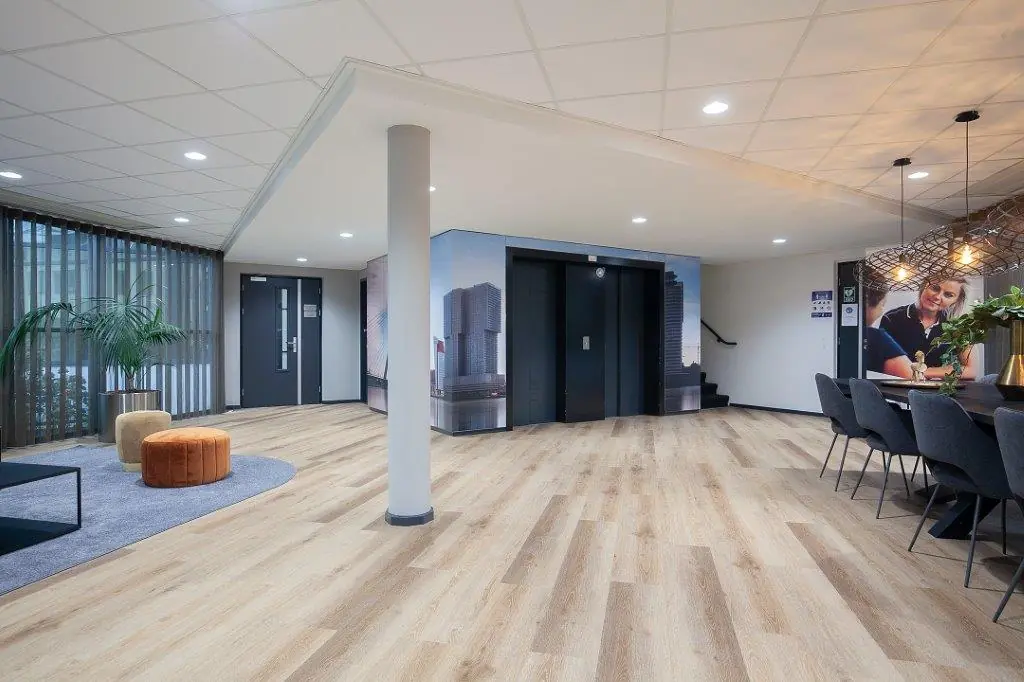 Moderne en strak ingerichte kantoorlobby aan de Cypresbaan met zithoek, lift en vergadertafel.