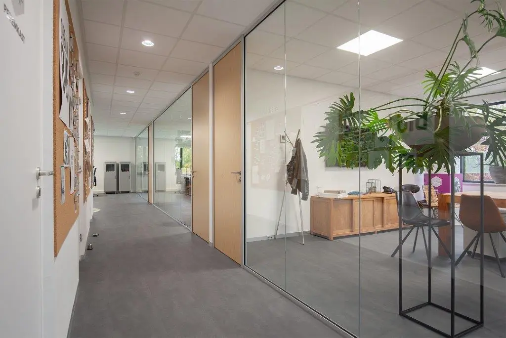 Moderne kantoorruimte aan de Cypresbaan met glazen wanden, vergaderruimte en een lange gang met prikborden.